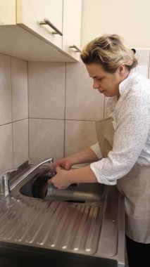 Akan suyun altında balık yıkayan kadın. Balık yemeği hazırlıyorum..