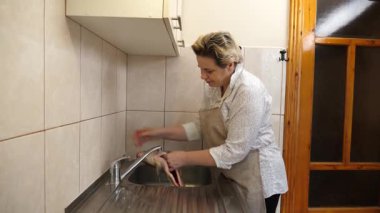 Akan suyun altında balık yıkayan kadın. Balık yemeği hazırlıyorum..