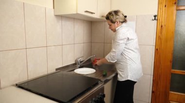 Suyun altında sebze yıkayan bir kadın. Taze sebzelerden yemek hazırlıyorum..