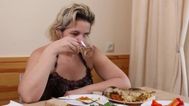 Bir kadın masada otururken kahve içer..