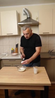 Bir adam krep pişirmek için hamur hazırlıyor. Elmalı krep yapıyorum..