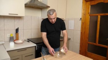 Bir adam krep pişirmek için hamur hazırlıyor. Elmalı krep yapıyorum..