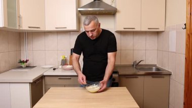 Bir adam krep pişirmek için hamur hazırlıyor. Elmalı krep yapıyorum..