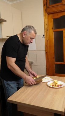 Bir adam elma keser ve rendeler. Elmalı yemek hazırlıyorum..