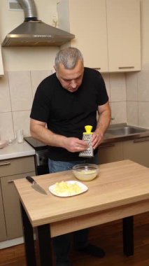 Bir adam elma keser ve rendeler. Elmalı yemek hazırlıyorum..