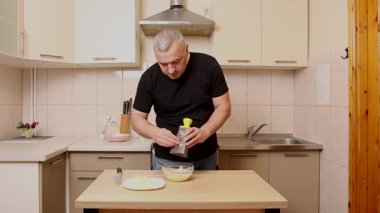 Bir adam elma keser ve rendeler. Elmalı yemek hazırlıyorum..