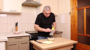 Bir adam elma keser ve rendeler. Elmalı yemek hazırlıyorum..