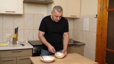 Bir adam krep pişirmek için hamur hazırlıyor. Elmalı krep yapıyorum..