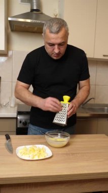 Bir adam elma keser ve rendeler. Elmalı yemek hazırlıyorum..