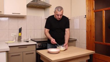 Bir adam krep pişirmek için hamur hazırlıyor. Elmalı krep yapıyorum..