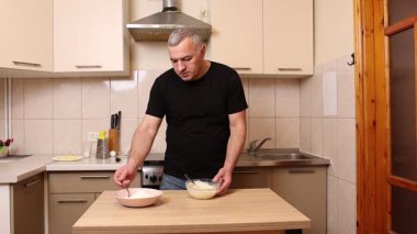 Bir adam krep pişirmek için hamur hazırlıyor. Elmalı krep yapıyorum..