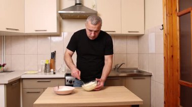 Bir adam krep pişirmek için hamur hazırlıyor. Elmalı krep yapıyorum..