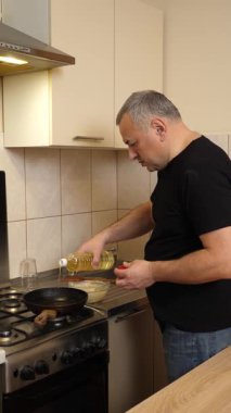 Bir adam tavada krep pişirir. Krep pişiriyorum..