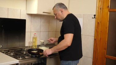 Bir adam tavada krep pişirir. Krep pişiriyorum..