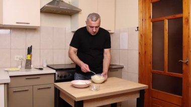 Bir adam krep pişirmek için hamur hazırlıyor. Elmalı krep yapıyorum..