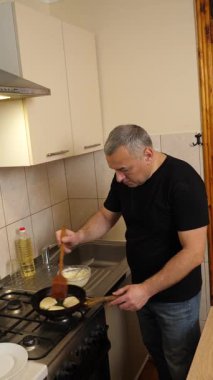 Bir adam tavada krep pişirir. Krep pişiriyorum..