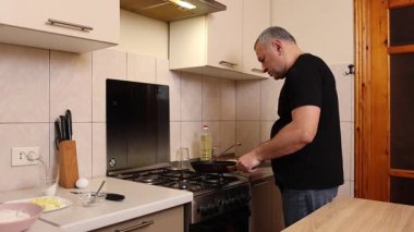 Bir adam tavada krep pişirir. Krep pişiriyorum..