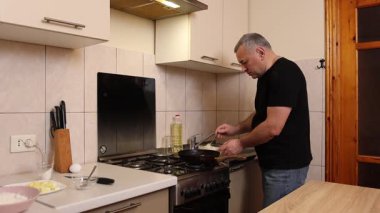 Bir adam tavada krep pişirir. Krep pişiriyorum..