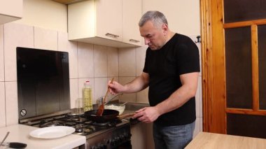 Bir adam tavada krep pişirir. Krep pişiriyorum..