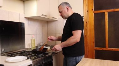 Bir adam tavada krep pişirir. Krep pişiriyorum..