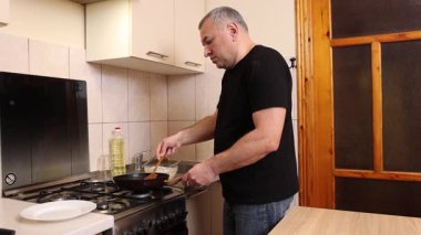 Bir adam tavada krep pişirir. Krep pişiriyorum..