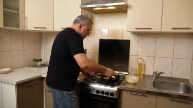 Bir adam tavada krep pişirir. Krep pişiriyorum..