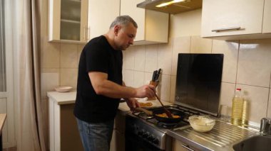 Bir adam tavada krep pişirir. Krep pişiriyorum..