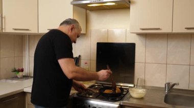 Bir adam tavada krep pişirir. Krep pişiriyorum..