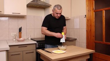 Bir adam elma keser ve rendeler. Elmalı yemek hazırlıyorum..