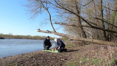 Bir adam ve bir kadın nehir kenarında piknik yaptılar..