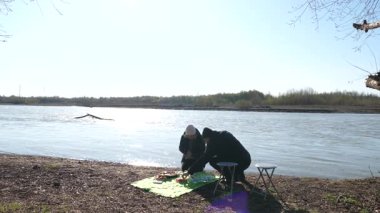 Bir adam ve bir kadın nehir kenarında piknik yaptılar..