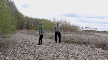 Bir erkek ve bir kadın nehir kenarında fiziksel egzersiz yapıyorlar..