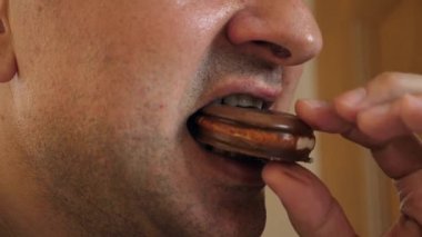 Adam evde masada otururken pasta yiyor.