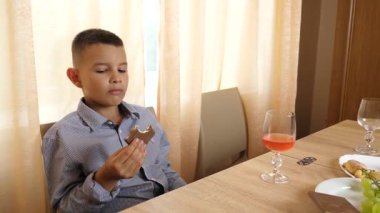 Evdeki masada çikolata yiyen çocuk.