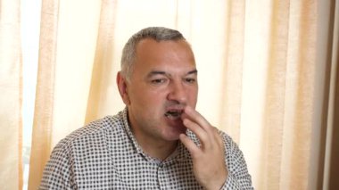 Evdeki masada çikolata yiyen adam.