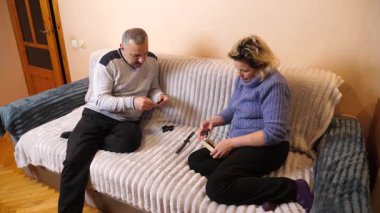 Bir adam ve bir kadın kanepede otururken domino oynuyorlar..