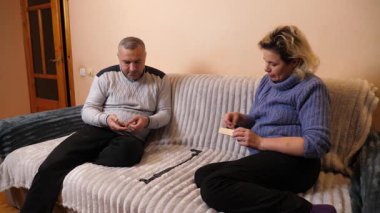 Bir adam ve bir kadın kanepede otururken domino oynuyorlar..