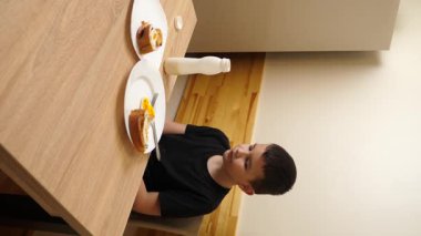 Bir adam masada otururken hamur işi yer, çay içer ve yoğurt içer..