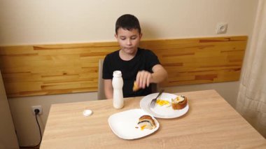 Bir adam masada otururken hamur işi yer, çay içer ve yoğurt içer..