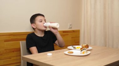 Bir adam masada otururken hamur işi yer, çay içer ve yoğurt içer..