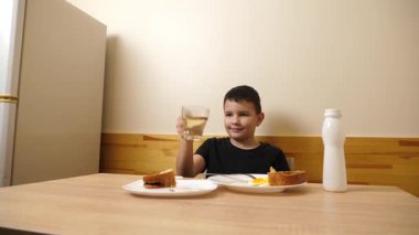 Bir adam masada otururken hamur işi yer, çay içer ve yoğurt içer..