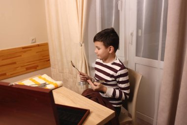 Oğlan çatal ve mutfak bıçaklarını siliyor. Ev işleri..