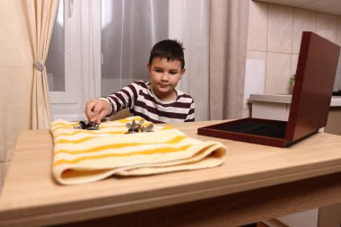 Oğlan çatal ve mutfak bıçaklarını siliyor. Ev işleri..