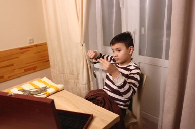 Oğlan çatal ve mutfak bıçaklarını siliyor. Ev işleri..