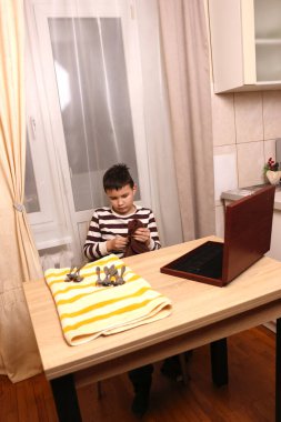 Oğlan çatal ve mutfak bıçaklarını siliyor. Ev işleri..