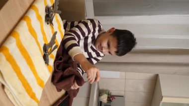 Oğlan çatal ve mutfak bıçaklarını siliyor. Ev işleri..