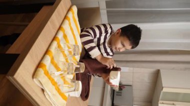 Oğlan bardakları ve bardakları havluyla siler. Ev işleri..