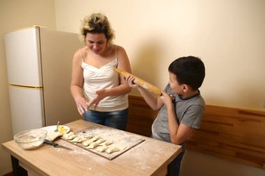 Bir çocuk ve annesi elmalı puf böreği yapıyorlar. Ev yemeği..