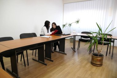 İki kız iş konuşmak ve kontrat imzalamak için ofiste buluşuyor..