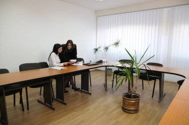 İki kız iş konuşmak ve kontrat imzalamak için ofiste buluşuyor..